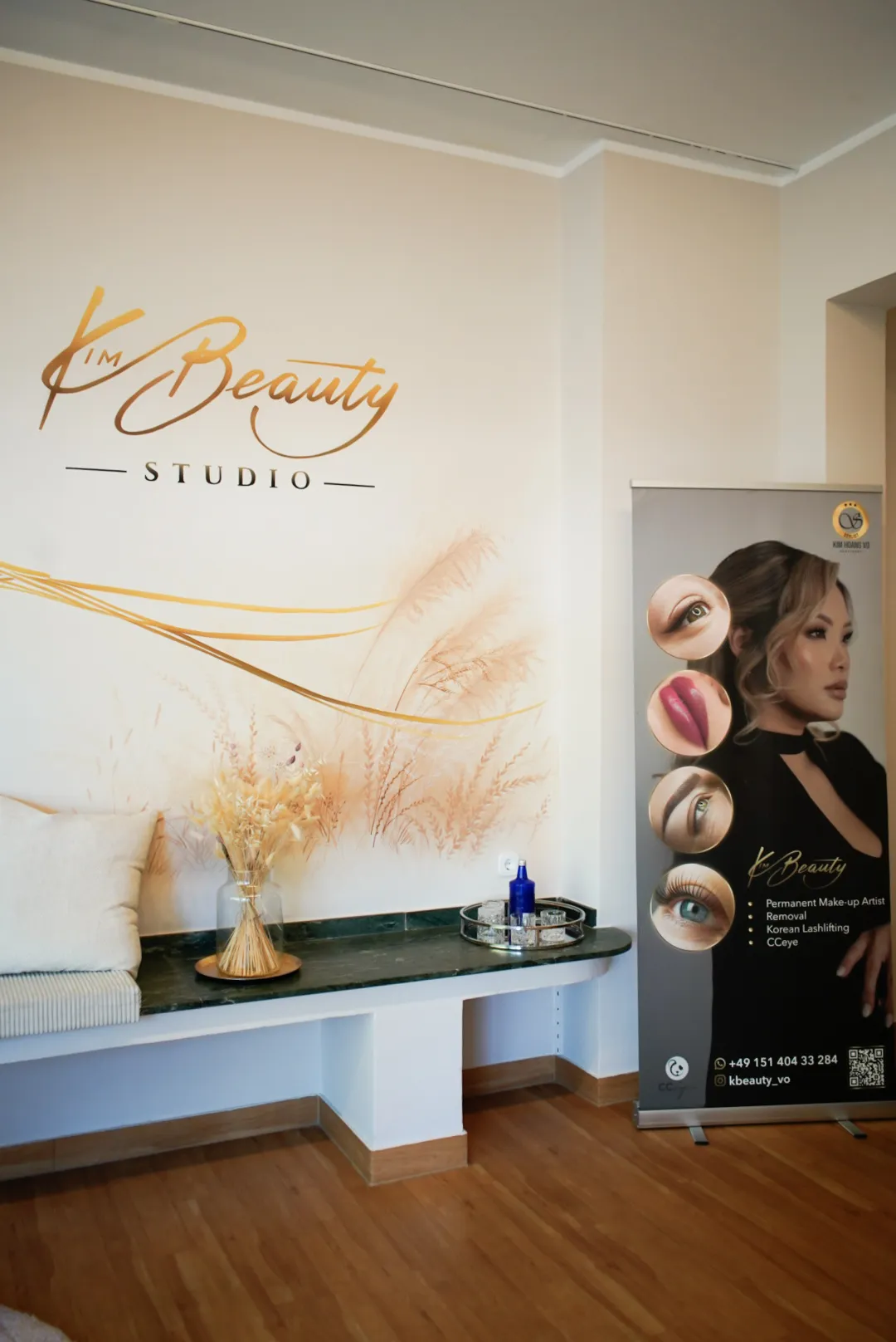 Empfangsbereich im KBeauty Studio mit goldenem Schriftzug an der Wand